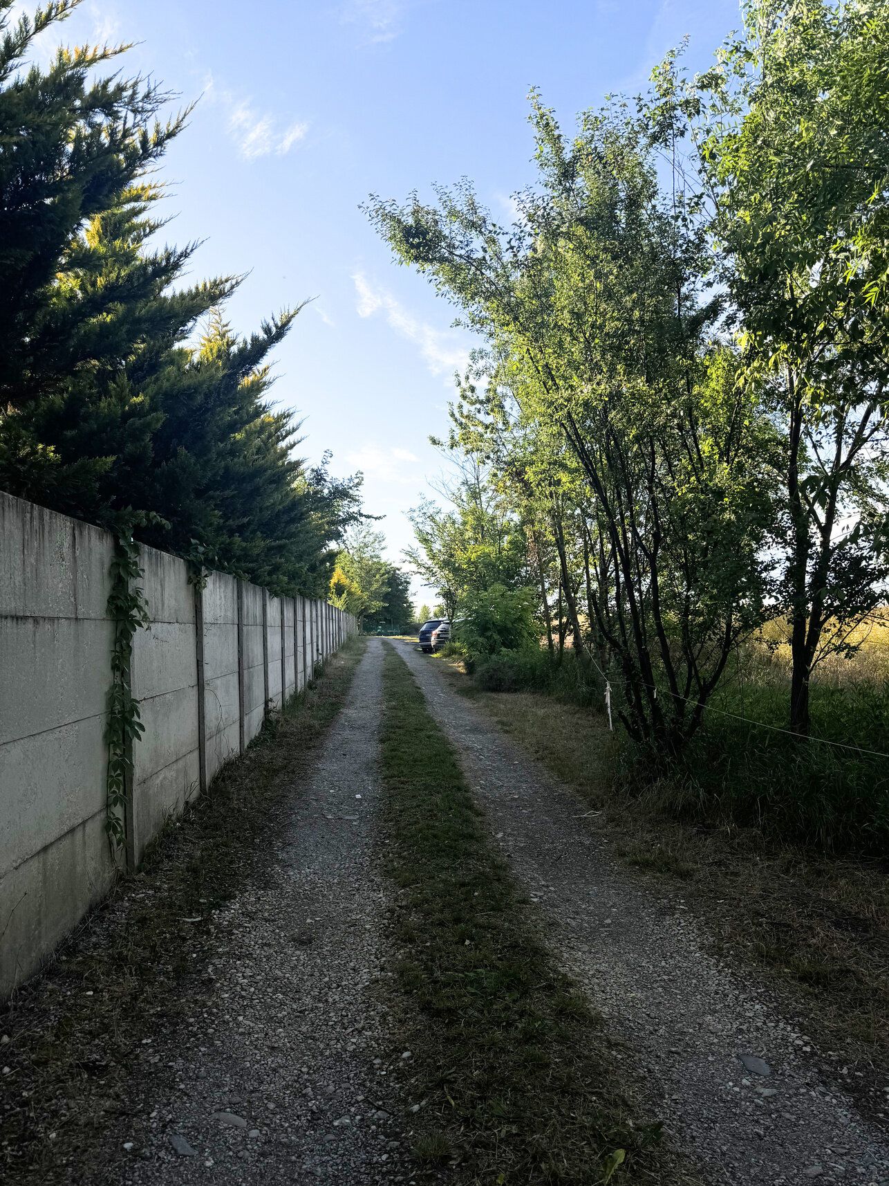Cesta na parkovisko pozdĺž dlhého betónového plota